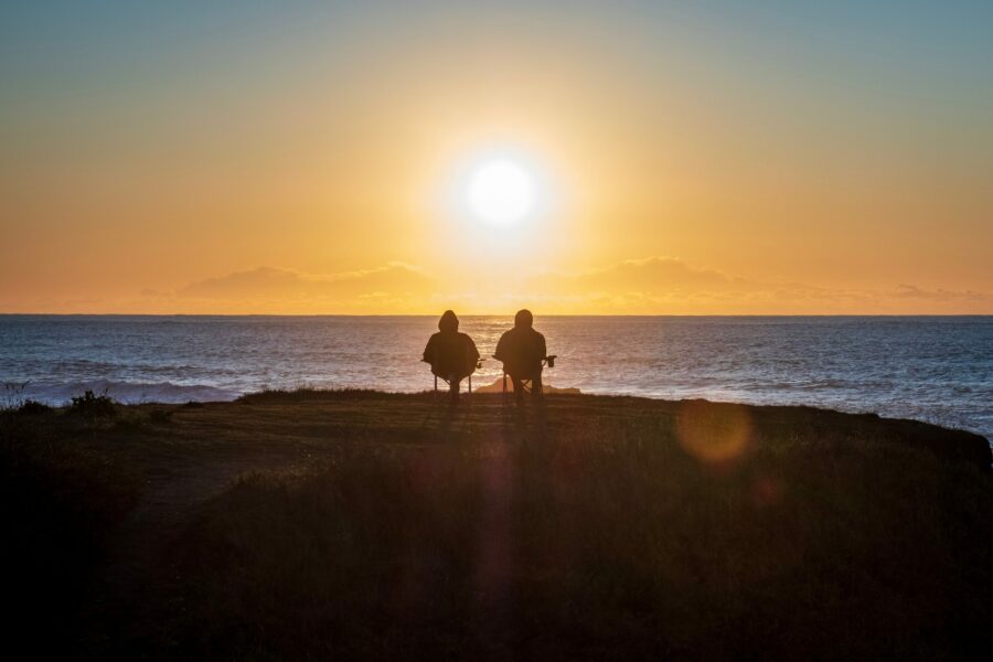 retired couple on beach at sunset